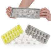 Hände entfernen Eiskugeln aus einer grauen Form.