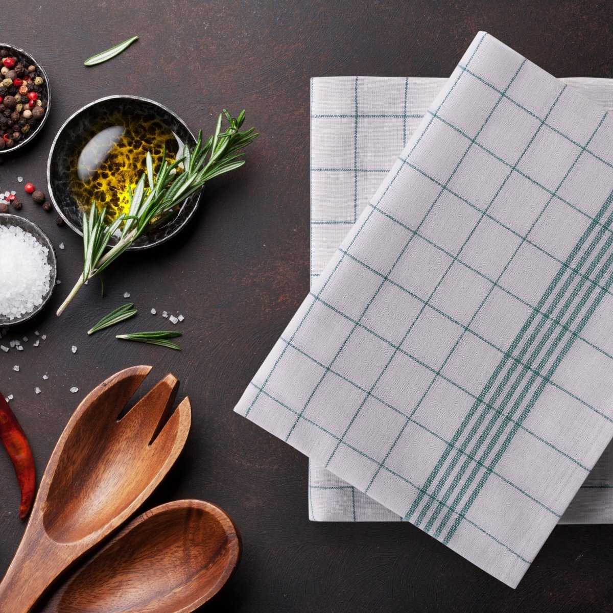 Geschirrtücher liegen auf einer Arbeitsfläche mit Kochzutaten.