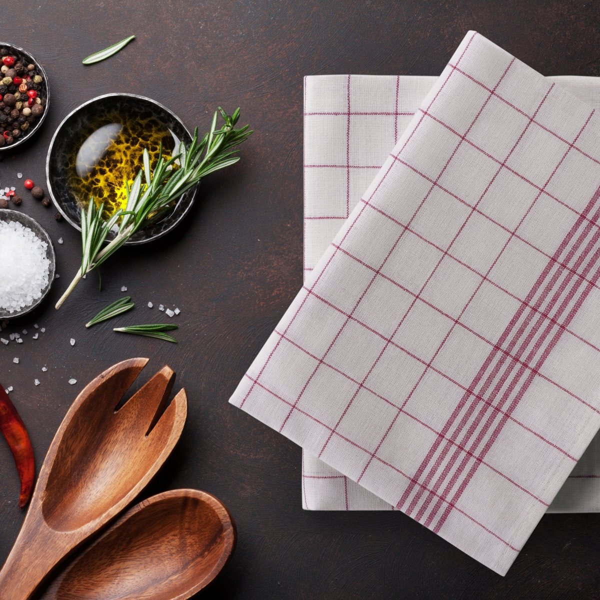 Geschirrtücher liegen auf einer Arbeitsfläche mit Kochzutaten.