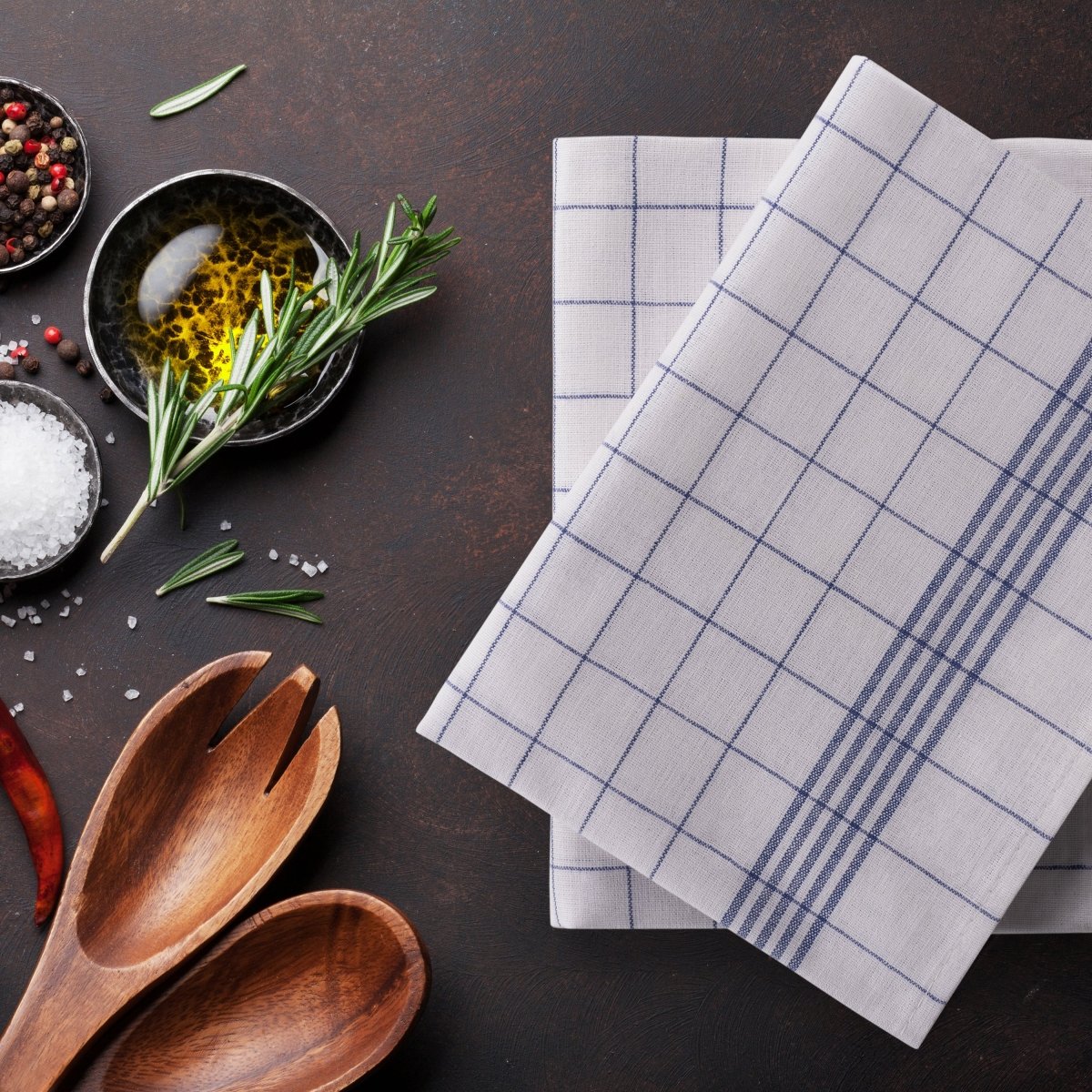 Geschirrtücher liegen auf einer Arbeitsfläche mit Kochzutaten.