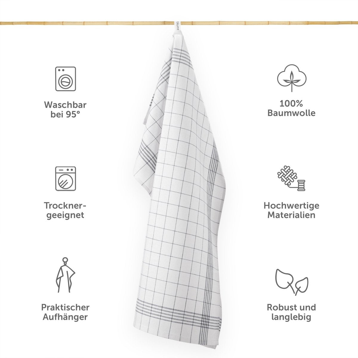Geschirrtuch hängt an einer Leiste mit Symbolen für Waschbarkeit Materialqualität und praktischen Eigenschaften.