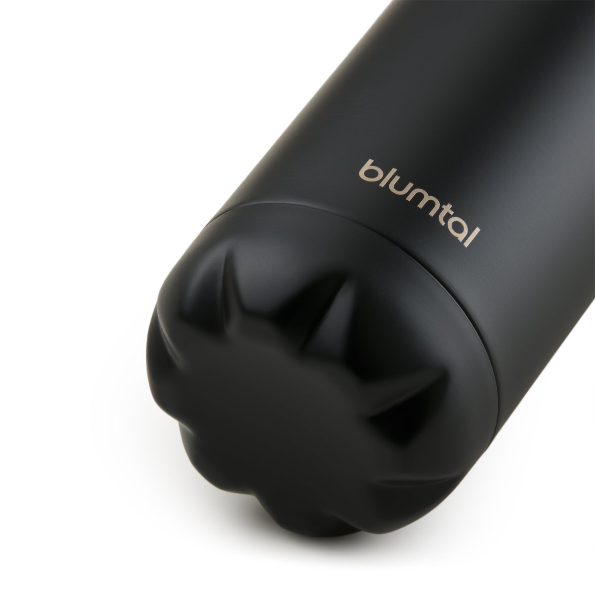 Nahaufnahme des Bodens einer schwarz blumtal Edelstahl-Trinkflasche die auf einer weißen Oberfläche steht.