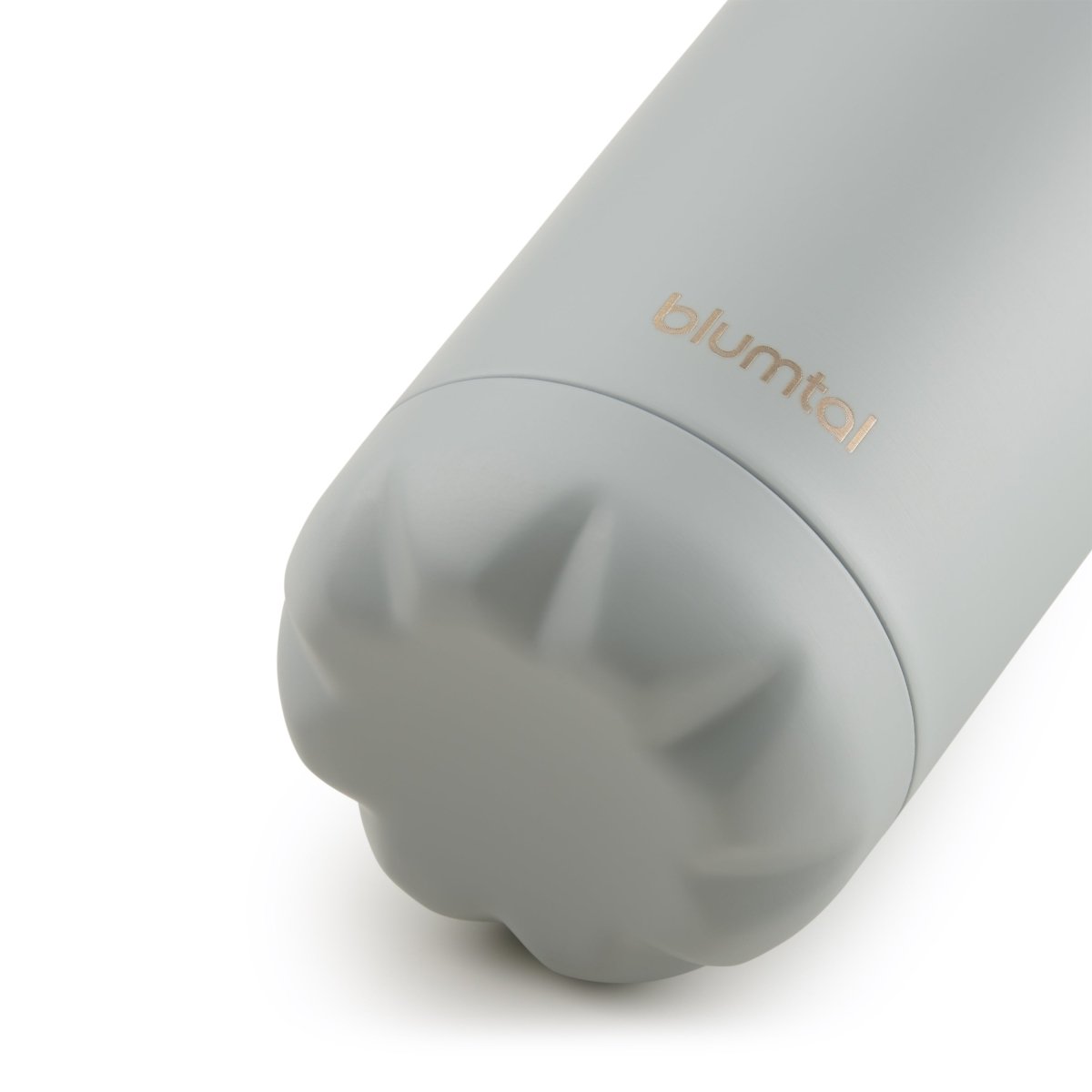 Nahaufnahme des Bodens einer ultimate grau blumtal Edelstahl-Trinkflasche die auf einer weißen Oberfläche steht.