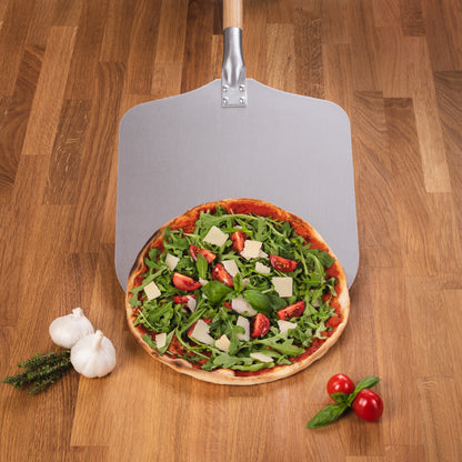 Leckere frische Pizza mit Rucola, Parmesan und Tomaten auf einer hochwertigen, robusten Pizzaschaufel aus Metall.