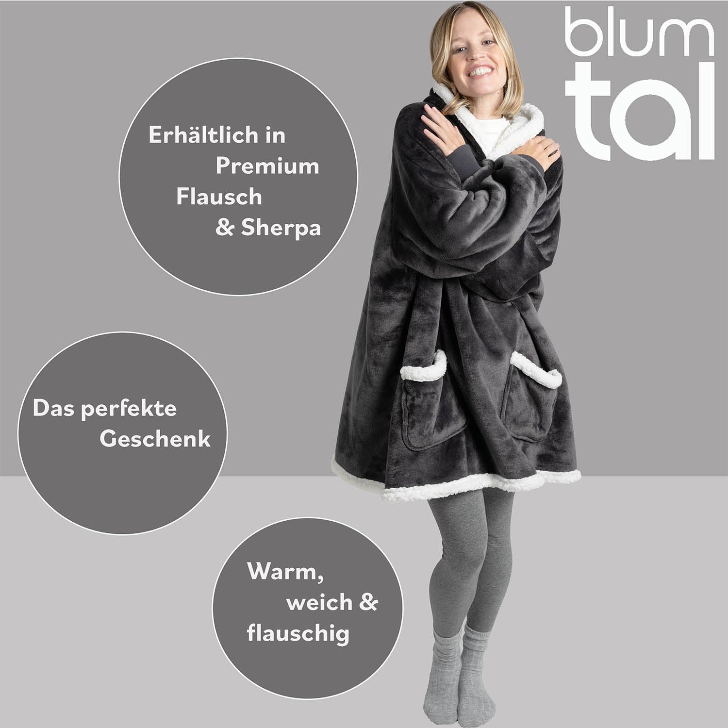 Lächelnde Frau in grauer Leggings mit einer anthrazitfarbenen Sherpa-Kuscheljacke, Text hervorhebt Verfügbarkeit in Premium Flausch und Sherpa als ideales Geschenk.