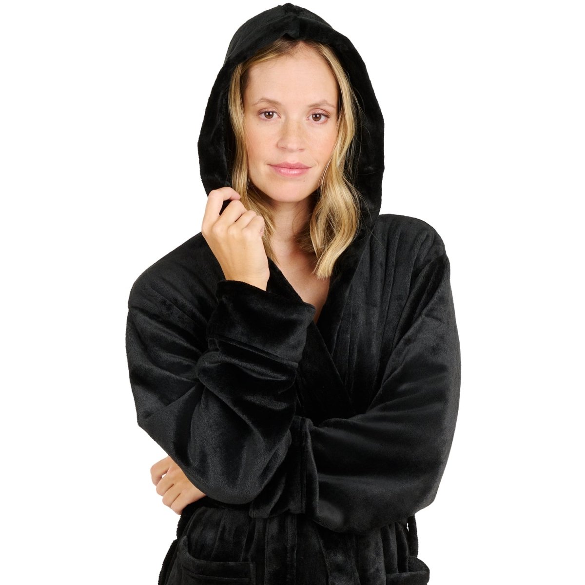 Eine Frau mit einem Fleece-Bademantel die lächelnd die Kapuze über den Kopf gezogen hat isoliert auf weißem Hintergrund.