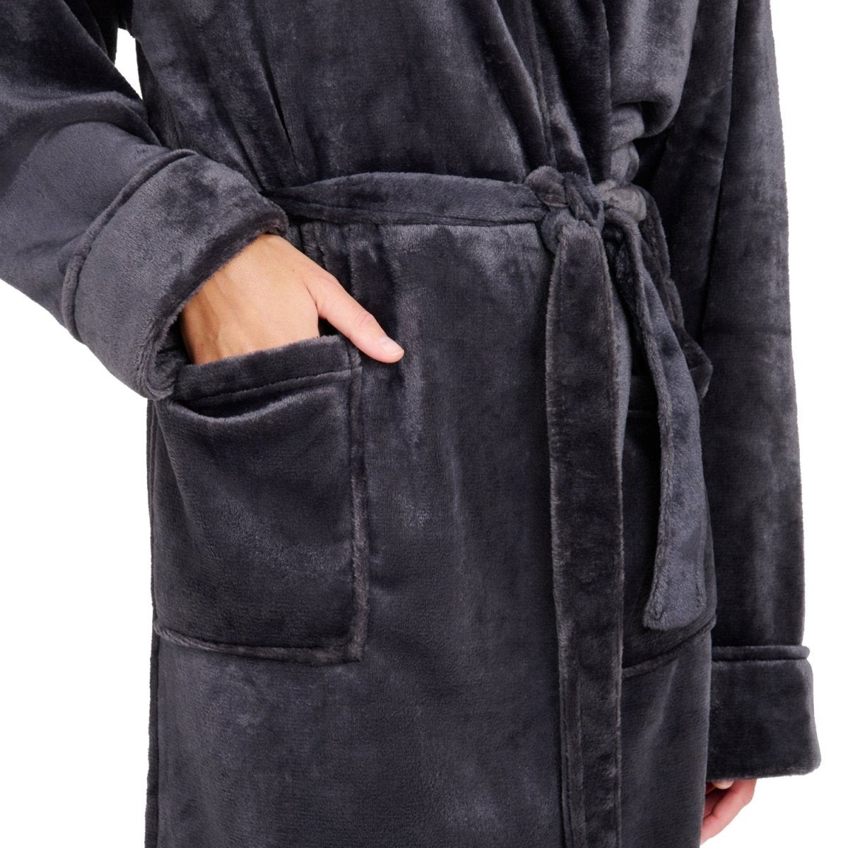 Detailansicht der Tasche eines Fleece-Bademantels in die eine Hand eingesteckt ist isoliert auf weißem Hintergrund.