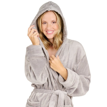 Eine Frau mit einem Fleece-Bademantel die lächelnd die Kapuze über den Kopf gezogen hat isoliert auf weißem Hintergrund.