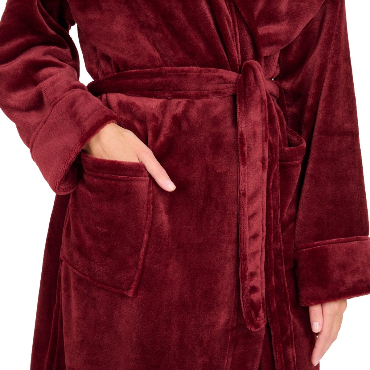 Detailansicht der Tasche eines Fleece-Bademantels in die eine Hand eingesteckt ist isoliert auf weißem Hintergrund.