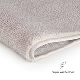 Nahaufnahme des Badezimmerteppichs mit Text Super weicher Flor.