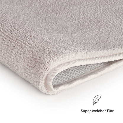 Nahaufnahme des Badezimmerteppichs mit Text Super weicher Flor.