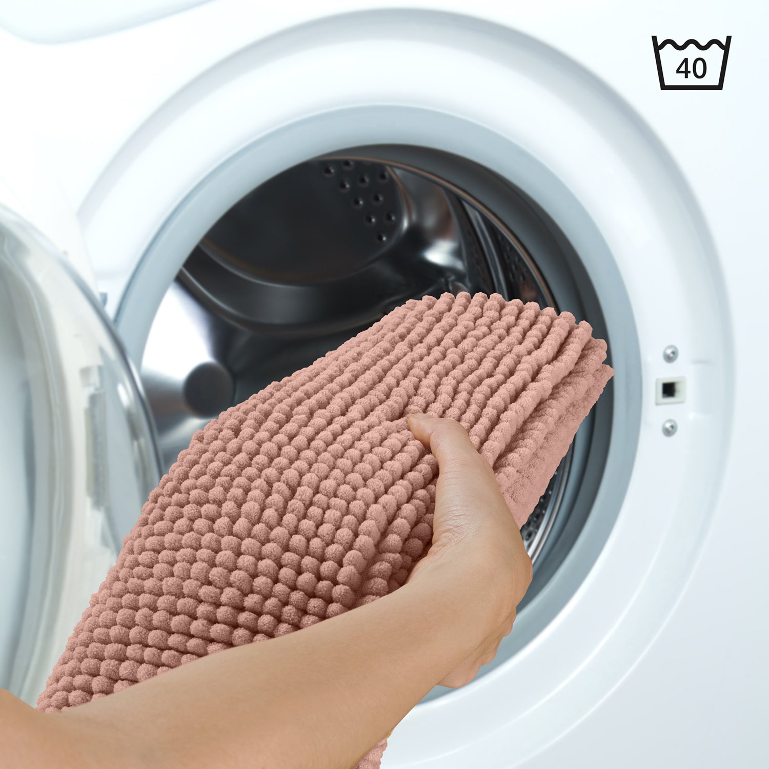 Rosa Chenille-Badematte wird in eine Waschmaschine gelegt Symbol 40 Grad.