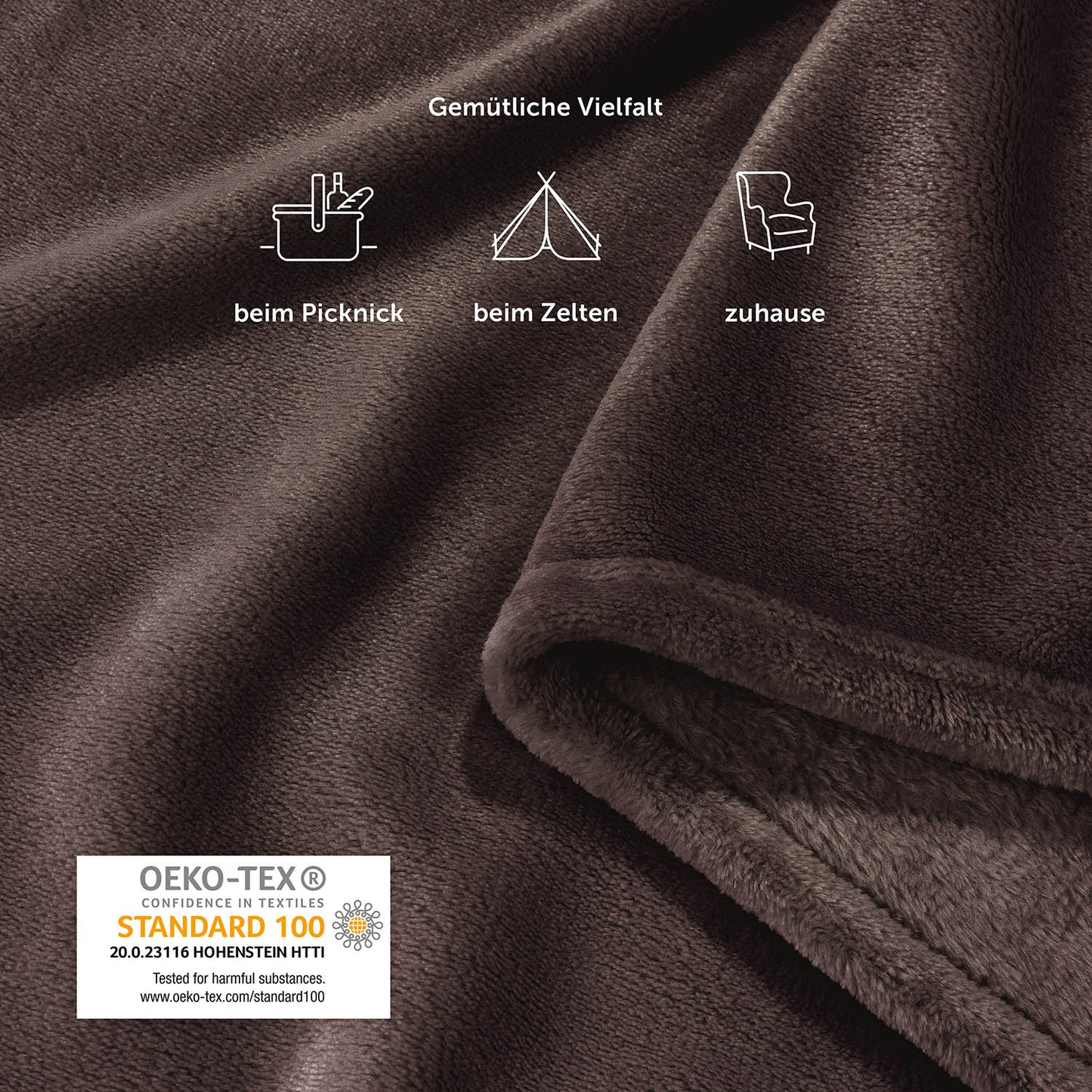 Nahaufnahme einer braunen Fleece-Kuscheldecke mit Piktogrammen, die Verwendung beim Picknick, Zelten und zu Hause anzeigen, neben dem OEKO-TEX Siegel.