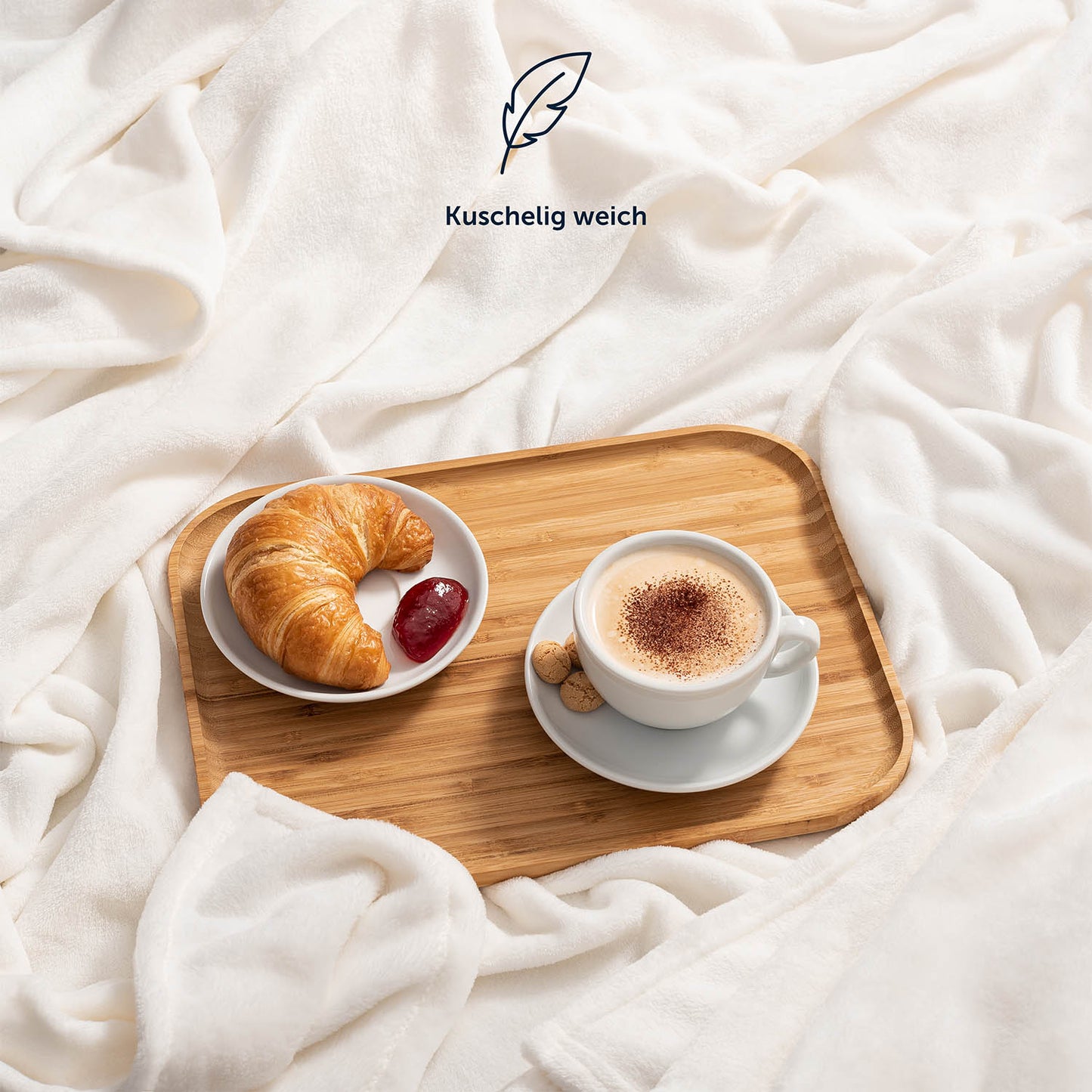 Hellblaue Fleece-Kuscheldecke auf einem Bett, mit einem Serviertablett, das ein Frühstück mit Kaffee und Croissant präsentiert, und der Beschreibung 'Kuschelig weich'.