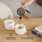 French-Press beim Ausgießen von Kaffee in zwei Tassen.