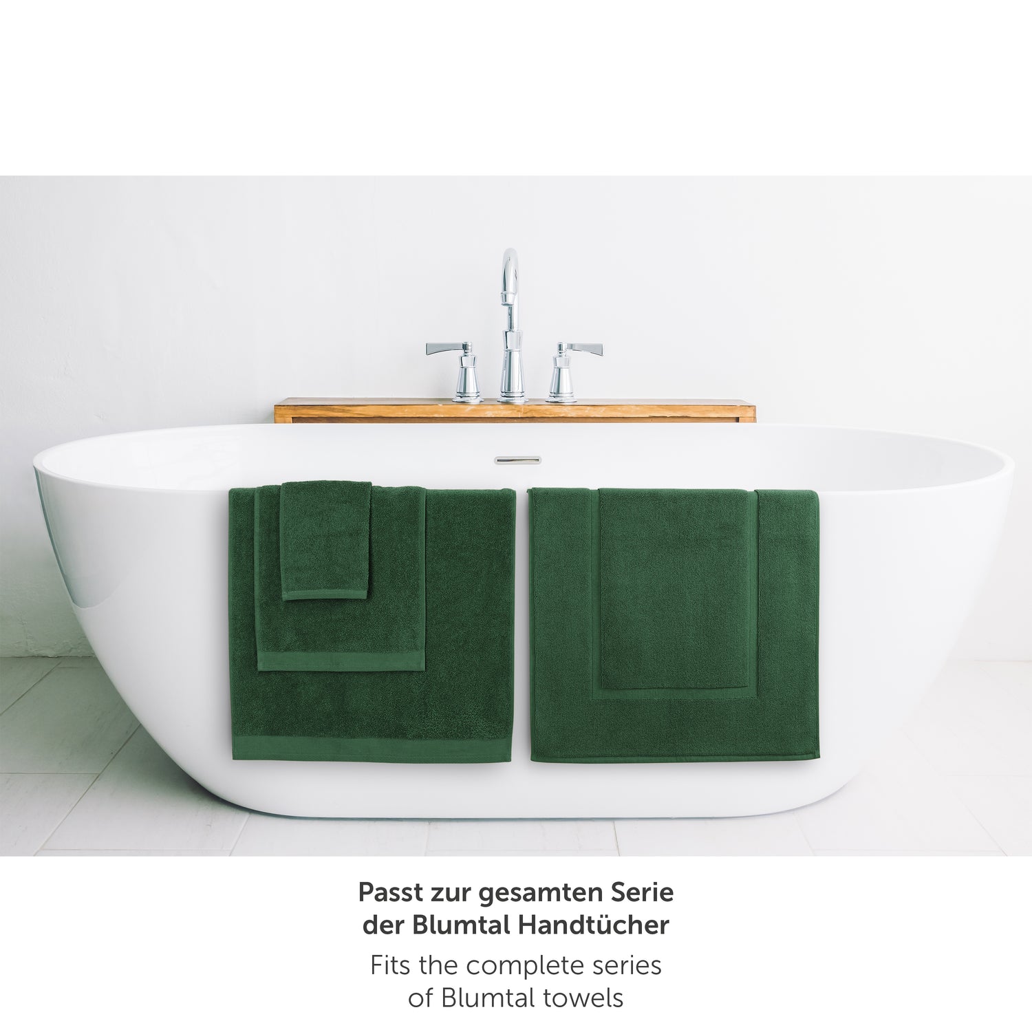 Gruenes Handtuch neben Badewanne passend zur Blumtal Handtuchserie.