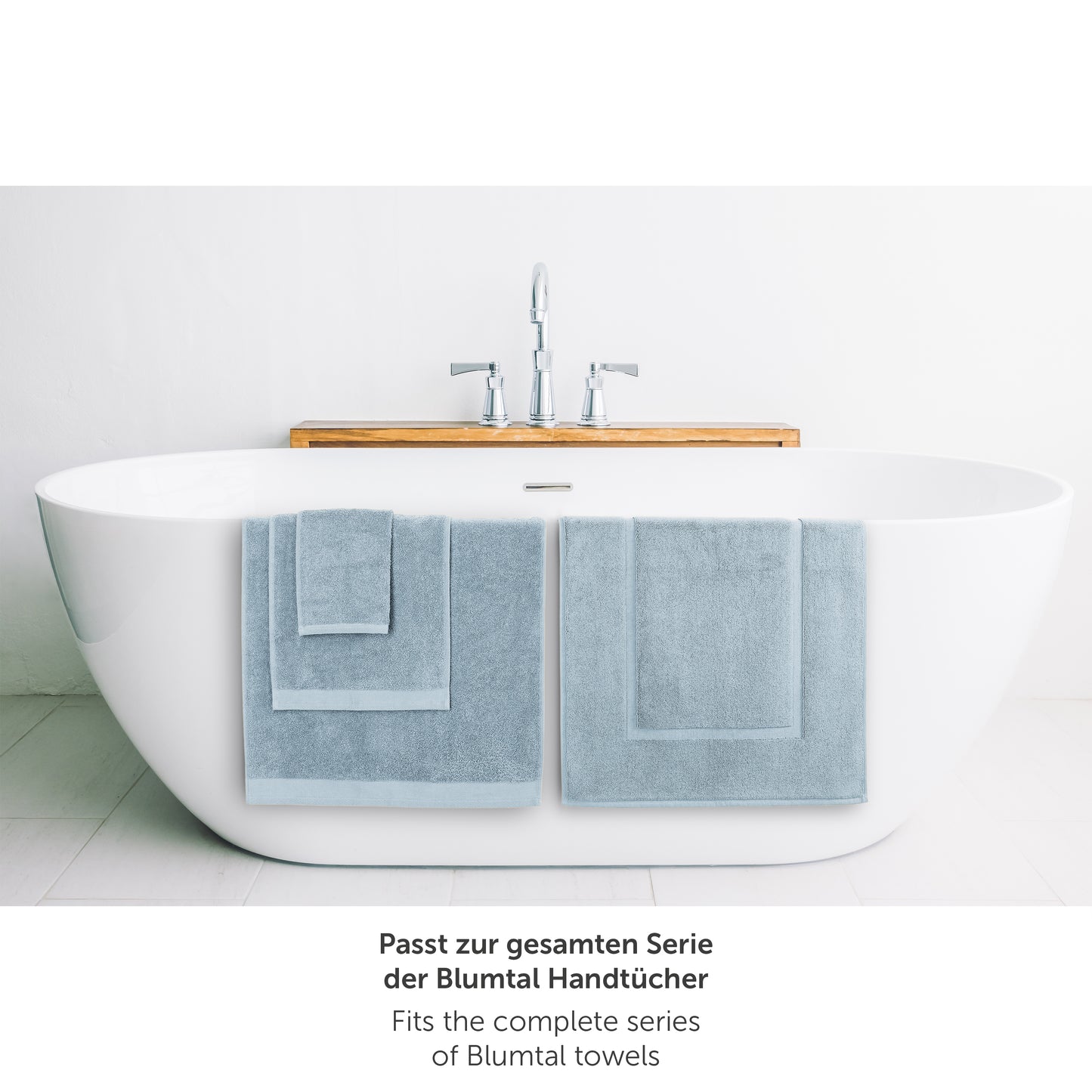 Hellblaues Handtuch neben Badewanne passend zur Blumtal Handtuchserie.