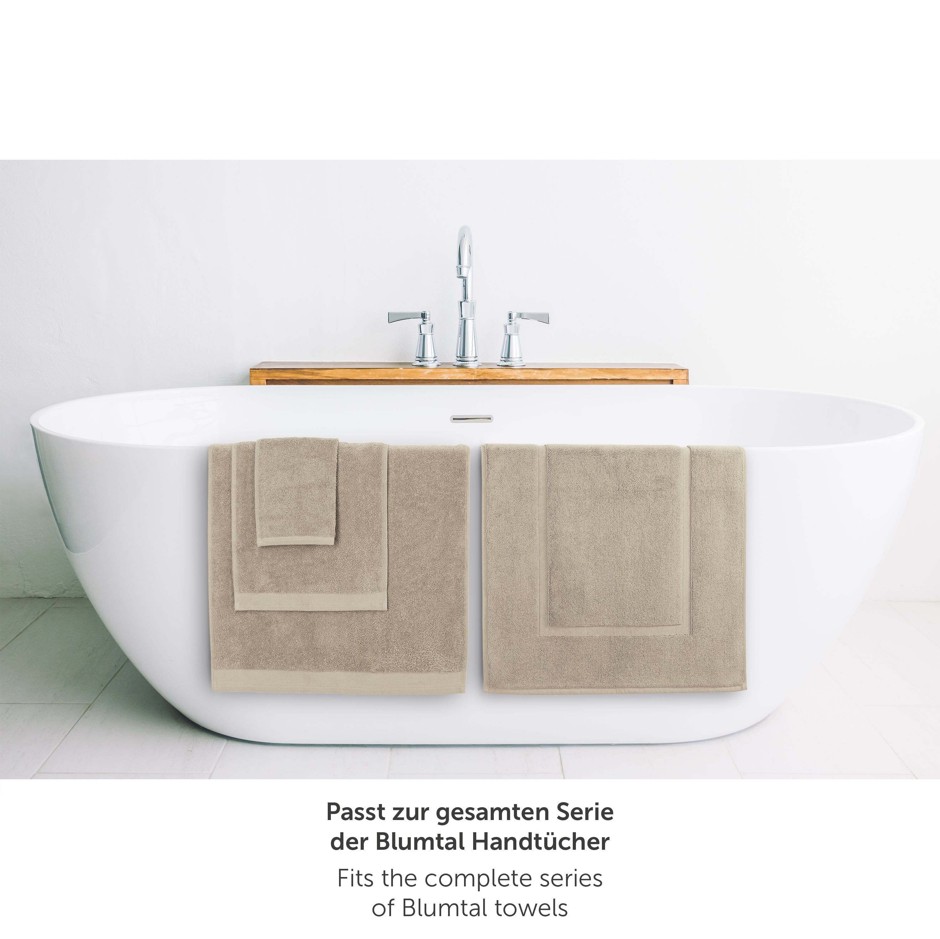 Taupe Handtuch neben Badewanne passend zur Blumtal Handtuchserie.