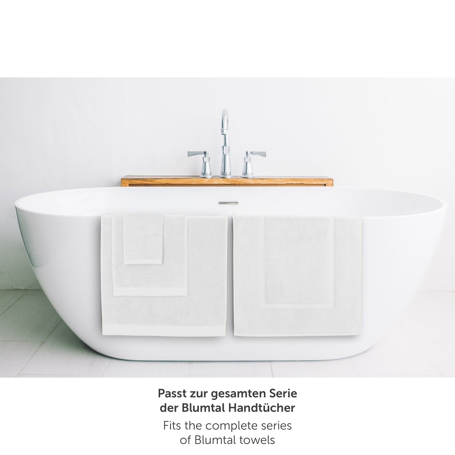 Weisses Handtuch neben Badewanne passend zur Blumtal Handtuchserie.