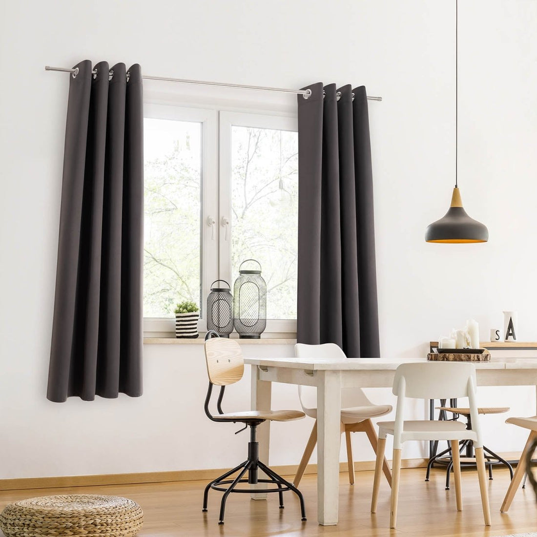 Stilvolle Raumgestaltung mit dunklen Vorhängen an einem Fenster das einem Esszimmer Tageslicht und Privatsphäre bietet.