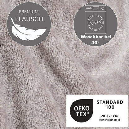 Detailansicht der Textur einer grauen Flausch-Kuscheljacke mit Waschhinweis bei 40 Grad und OEKO-TEX Standard 100 Zertifizierung.
