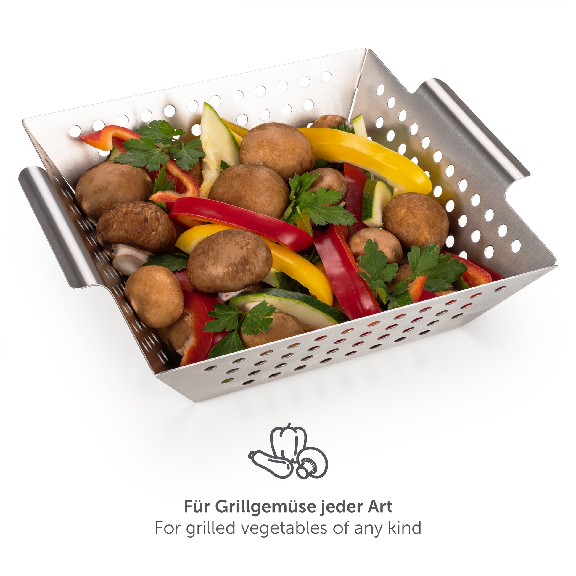Kleiner Edelstahl-Grillkorb mit Gemüse und Pilzen auf einer Grillfläche.