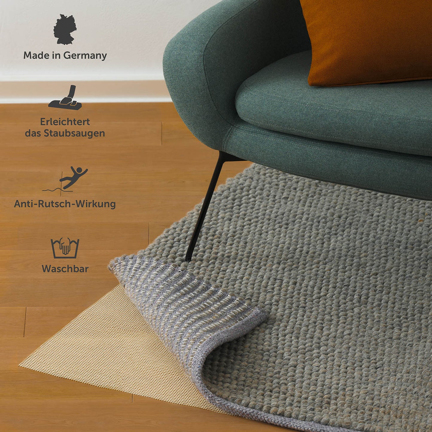 Antirutschmatte unter einem grauen Teppich mit grünem Stuhl darauf, Text hervorhebt "Made in Germany", waschbar und Anti-Rutsch-Eigenschaften.