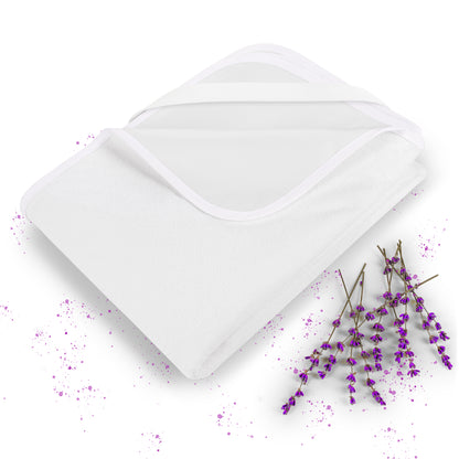 Weißer Matratzenschoner umgeben von lila Lavendelblüten und violetten Spritzern.