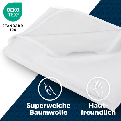 Gefalteter weißer Matratzenschoner mit OEKO-TEX Standard 100 Label, Symbolen für superweiche Baumwolle und Hautfreundlichkeit auf blauem Hintergrund.