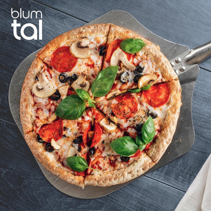 Frisch gebackene Pizza mit Salami, Pilzen, Oliven und Basilikumblättern auf einer Aluminiumschaufel von Blumtal.