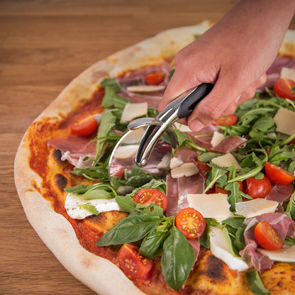 Hand bedient den Pizzaschneider beim Schneiden der Pizza.