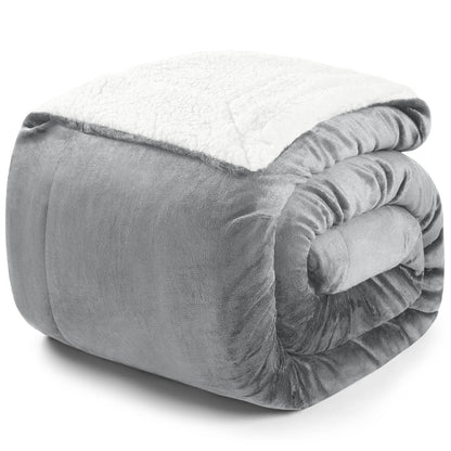 Zusammengerollte graue Decke mit weißer Fleece-Innenseite auf weißem Hintergrund.