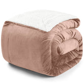 Zusammengerollte rosa Decke mit weißer Fleece-Innenseite auf weißem Hintergrund.