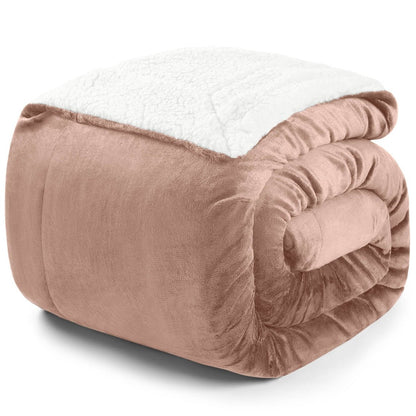 Zusammengerollte rosa Decke mit weißer Fleece-Innenseite auf weißem Hintergrund.