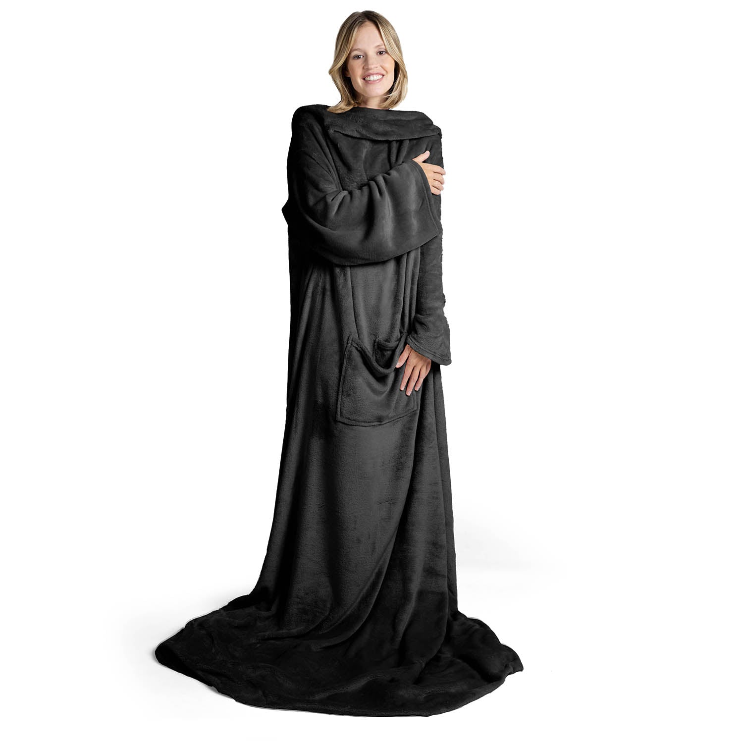 Lächelnde Frau in einem übergroßen anthrazit flauschigen Kleidungsstück das bis zum Boden reicht steht vor weißem Hintergrund.