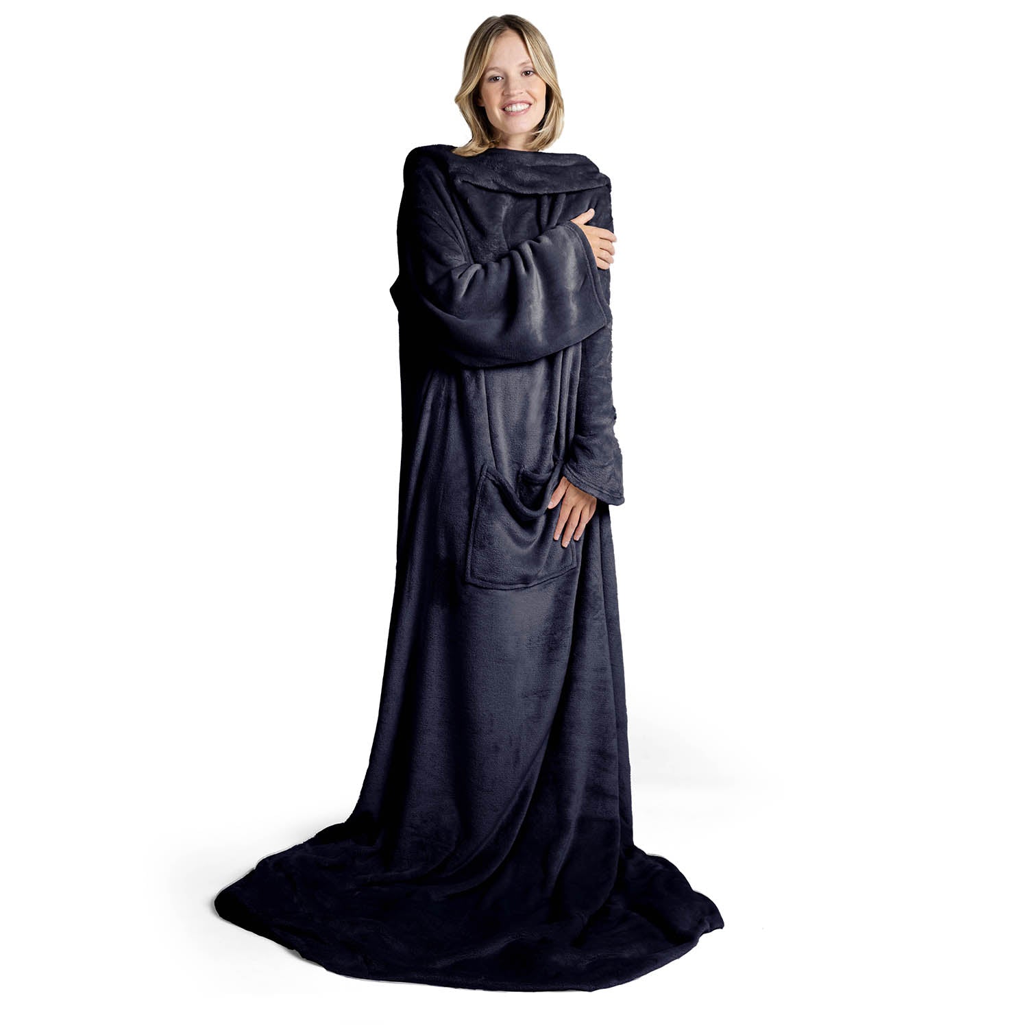 Lächelnde Frau in einem übergroßen dunkelblau flauschigen Kleidungsstück das bis zum Boden reicht steht vor weißem Hintergrund.