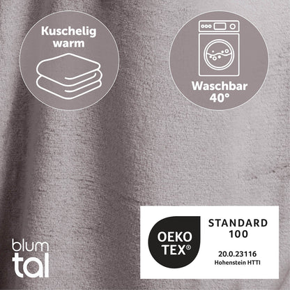 Detailansicht des grauen flauschigen Stoffes mit Symbolen für Kuschelwärme und Waschbarkeit bei 40 Grad sowie OEKO-TEX Standard 100 Zertifizierung.