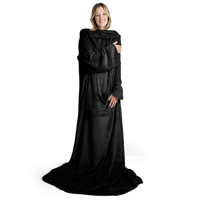 Lächelnde Frau in einem übergroßen schwarz flauschigen Kleidungsstück das bis zum Boden reicht steht vor weißem Hintergrund.