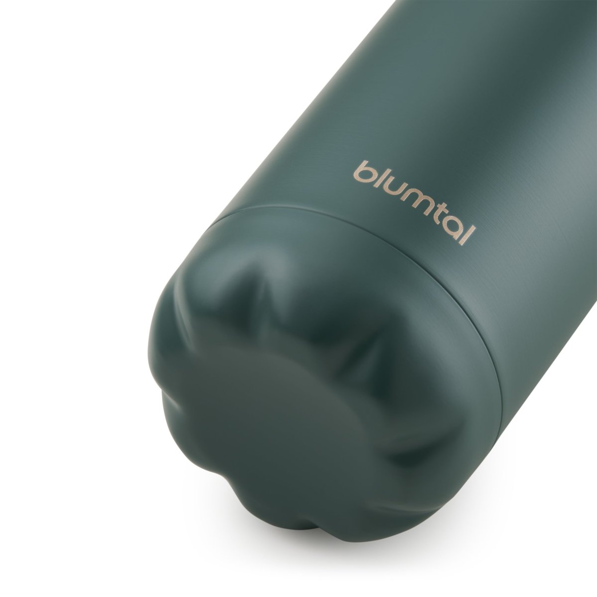 Nahaufnahme des Bodens einer dunkelgrün blumtal Edelstahl-Trinkflasche die auf einer weißen Oberfläche steht.