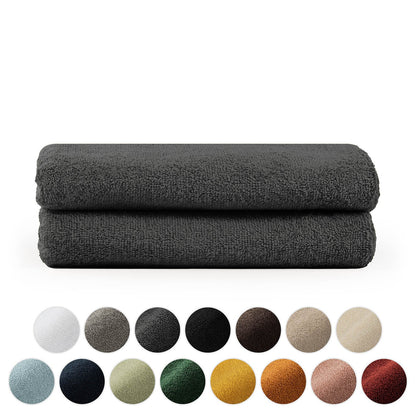 Stapel von zwei gefalteten Handtüchern mit einer Palette verschiedener Farbkreise darunter in Weiß Grau Schwarz Brauntönen Blau Grün Gelb und Rot